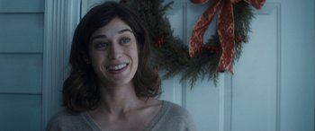 Movie still from “The Night Before” (2015), directed by Jonathan Levine – A person smiling near a christmas wreath; Close Up shot, Over the shoulder angle