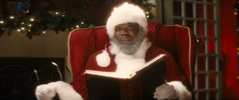 Movie still from “The Night Before” (2015), directed by Jonathan Levine – A man in a santa claus outfit holding a book; Close Up shot, Low angle