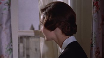 Movie still from “The Nun's Story” (1959), directed by Fred Zinnemann – A woman in a black suit looking out of a window; Close Up shot, Low angle