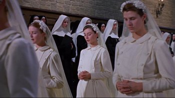 Movie still from “The Nun's Story” (1959), directed by Fred Zinnemann – A group of people standing next to each other in a room; Medium shot, High angle