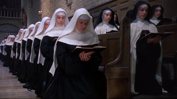 Movie still from “The Nun's Story” (1959), directed by Fred Zinnemann – A group of women in a row of pews reading; Medium shot, High angle