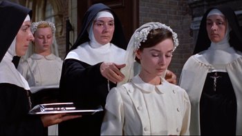 Movie still from “The Nun's Story” (1959), directed by Fred Zinnemann – A nun is putting a veil on a woman's head; Medium shot, Low angle