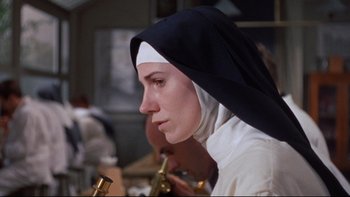 Movie still from “The Nun's Story” (1959), directed by Fred Zinnemann – A woman in a nun's outfit is holding a pipe; Close Up shot, Low angle
