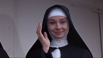 Movie still from “The Nun's Story” (1959), directed by Fred Zinnemann – A woman wearing a nun's habit and holding her hand up; Close Up shot, Low angle