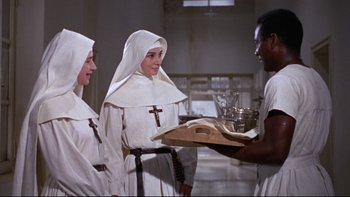 Movie still from “The Nun's Story” (1959), directed by Fred Zinnemann – A group of nuns standing next to each other holding a tray; Medium shot, High angle