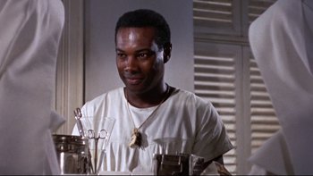 Movie still from “The Nun's Story” (1959), directed by Fred Zinnemann – A man in a white shirt is looking at the camera; Close Up shot, Low angle