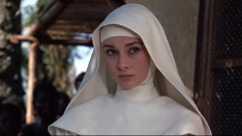 Movie still from “The Nun's Story” (1959), directed by Fred Zinnemann – A woman wearing a nun's habit and a white veil; Close Up shot, Low angle