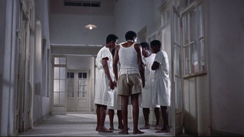 Movie still from “The Nun's Story” (1959), directed by Fred Zinnemann – A group of men standing in a room next to each other; Wide shot, High angle