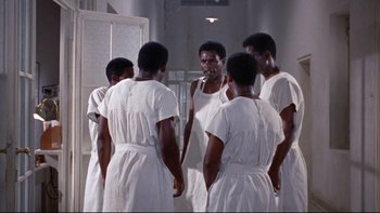 Movie still from “The Nun's Story” (1959), directed by Fred Zinnemann – A group of men in white robes standing in front of a bathroom mirror; Medium shot, High angle