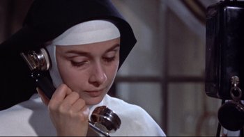 Movie still from “The Nun's Story” (1959), directed by Fred Zinnemann – A nun with a cell phone in her hand; Close Up shot, Low angle