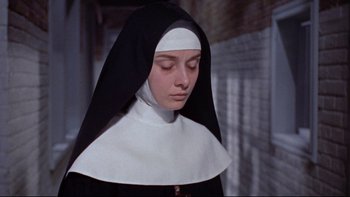 Movie still from “The Nun's Story” (1959), directed by Fred Zinnemann – A woman in a nun's habit is looking down; Close Up shot, Low angle
