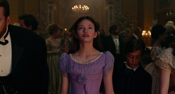 Movie still from “The Nutcracker and the Four Realms” (2018), directed by Joe Johnston – A woman in a purple dress standing in front of a crowd; Medium shot, Low angle