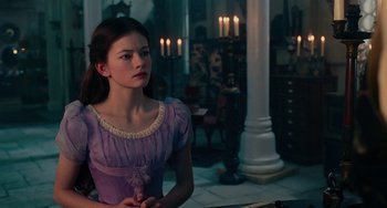 Movie still from “The Nutcracker and the Four Realms” (2018), directed by Joe Johnston – A girl in a purple dress sitting at a table in front of candles; Medium shot, Over the shoulder angle