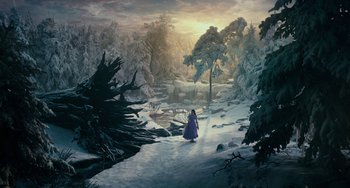 Movie still from “The Nutcracker and the Four Realms” (2018), directed by Joe Johnston – A woman in a purple dress walking through a snowy forest; Extreme Wide shot, High angle