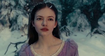 Movie still from “The Nutcracker and the Four Realms” (2018), directed by Joe Johnston – A woman in a purple dress in the snow; Close Up shot, Over the shoulder angle
