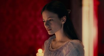 Movie still from “The Nutcracker and the Four Realms” (2018), directed by Joe Johnston – A young woman is standing in front of some candles; Close Up shot, Over the shoulder angle