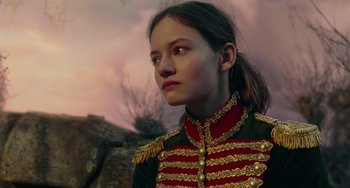 Movie still from “The Nutcracker and the Four Realms” (2018), directed by Joe Johnston – A young girl in a military uniform looking to her left; Close Up shot, Over the shoulder angle