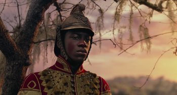 Movie still from “The Nutcracker and the Four Realms” (2018), directed by Joe Johnston – A man in a uniform and a hat is standing under a tree; Close Up shot, Low angle
