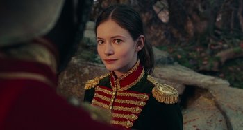 Movie still from “The Nutcracker and the Four Realms” (2018), directed by Joe Johnston – A young woman in a military uniform looking into the camera; Close Up shot, Over the shoulder angle