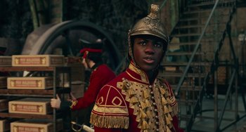 Movie still from “The Nutcracker and the Four Realms” (2018), directed by Joe Johnston – A man in a red and gold uniform with a helmet on; Close Up shot, Over the shoulder angle