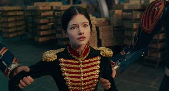 Movie still from “The Nutcracker and the Four Realms” (2018), directed by Joe Johnston – A woman in a military uniform holding a gun; Close Up shot, Over the shoulder angle