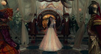 Movie still from “The Nutcracker and the Four Realms” (2018), directed by Joe Johnston – A woman in a long dress standing in front of a group of men; Wide shot, Low angle