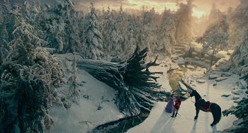 Movie still from “The Nutcracker and the Four Realms” (2018), directed by Joe Johnston – Two people standing in the snow next to trees; Extreme Wide shot, High angle