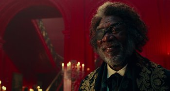Movie still from “The Nutcracker and the Four Realms” (2018), directed by Joe Johnston – An older man in a suit and tie smiling for the camera; Close Up shot, Low angle