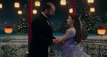 Movie still from “The Nutcracker and the Four Realms” (2018), directed by Joe Johnston – A man and a woman holding hands in front of a gazebo at night; Medium shot, Low angle