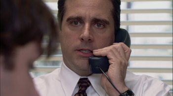 Movie still from “The Office” (2005), created by Ricky Gervais – A person talking on a phone; Close Up shot, Over the shoulder angle