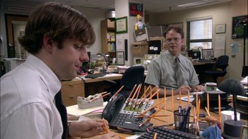 Movie still from “The Office” (2005), created by Ricky Gervais – Two men sitting in an office working on a computer; Medium shot, High angle