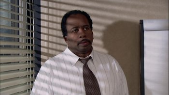 Movie still from “The Office” (2005), created by Ricky Gervais – A man wearing a white shirt and a brown tie; Close Up shot, High angle