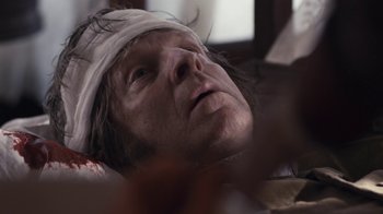 Movie still from “Anne with an E” (2017), created by Moira Walley-Beckett – A man with a bandage on his head is laying down; Close Up shot, Overhead angle