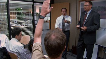 Movie still from “The Office” (2005), created by Ricky Gervais – A group of people standing in a room; Wide shot, Over the shoulder angle