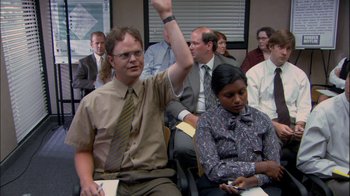 Movie still from “The Office” (2005), created by Ricky Gervais – A group of people sitting in a conference room; Medium shot, High angle