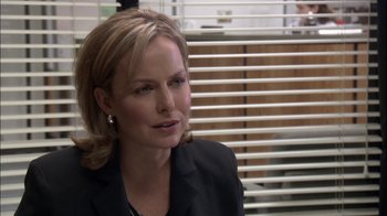 Movie still from “The Office” (2005), created by Ricky Gervais – A woman with blonde hair wearing a black jacket; Close Up shot, Over the shoulder angle