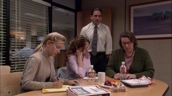 Movie still from “The Office” (2005), created by Ricky Gervais – A group of people sitting at a table with food; Wide shot, Over the shoulder angle