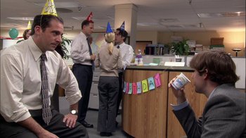Movie still from “The Office” (2005), created by Ricky Gervais – A group of people standing in a room; Medium shot, High angle