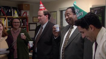 Movie still from “The Office” (2005), created by Ricky Gervais – A group of men standing next to each other holding cups; Medium shot, High angle