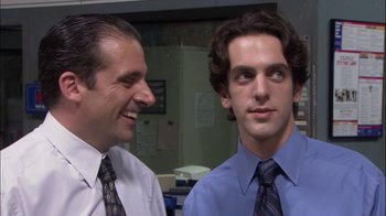 Movie still from “The Office” (2005), created by Ricky Gervais – Two men in dress shirts and ties are smiling for the camera; Close Up shot, Over the shoulder angle