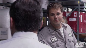 Movie still from “The Office” (2005), created by Ricky Gervais – A man in a gray shirt is talking to another man in a white shirt; Close Up shot, Over the shoulder angle
