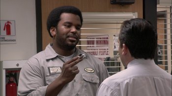 Movie still from “The Office” (2005), created by Ricky Gervais – A man talking to another man in front of a window; Medium shot, Over the shoulder angle