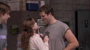 Movie still from “The Office” (2005), created by Ricky Gervais – A man and a woman standing next to each other; Medium shot, Over the shoulder angle