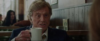 Movie still from “The Old Man & the Gun” (2018), directed by David Lowery – An older man holding a coffee mug in a restaurant; Close Up shot, Low angle