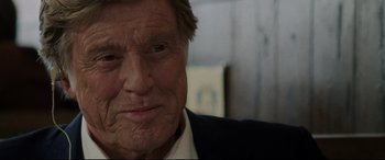 Movie still from “The Old Man & the Gun” (2018), directed by David Lowery – An older man with a beard and a suit; Close Up shot, Over the shoulder angle