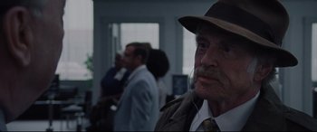 Movie still from “The Old Man & the Gun” (2018), directed by David Lowery – An old man with a mustache wearing a hat; Close Up shot, Over the shoulder angle