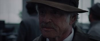 Movie still from “The Old Man & the Gun” (2018), directed by David Lowery – An old man with a hat and a mustache; Close Up shot, Over the shoulder angle