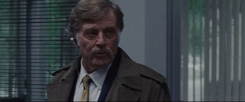 Movie still from “The Old Man & the Gun” (2018), directed by David Lowery – An older man wearing a suit and tie; Close Up shot, Over the shoulder angle