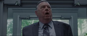 Movie still from “The Old Man & the Gun” (2018), directed by David Lowery – An older man wearing a suit and tie with his mouth wide open; Close Up shot, Low angle
