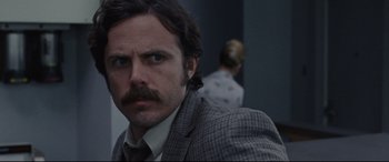 Movie still from “The Old Man & the Gun” (2018), directed by David Lowery – A person wearing a suit and tie; Close Up shot, Over the shoulder angle